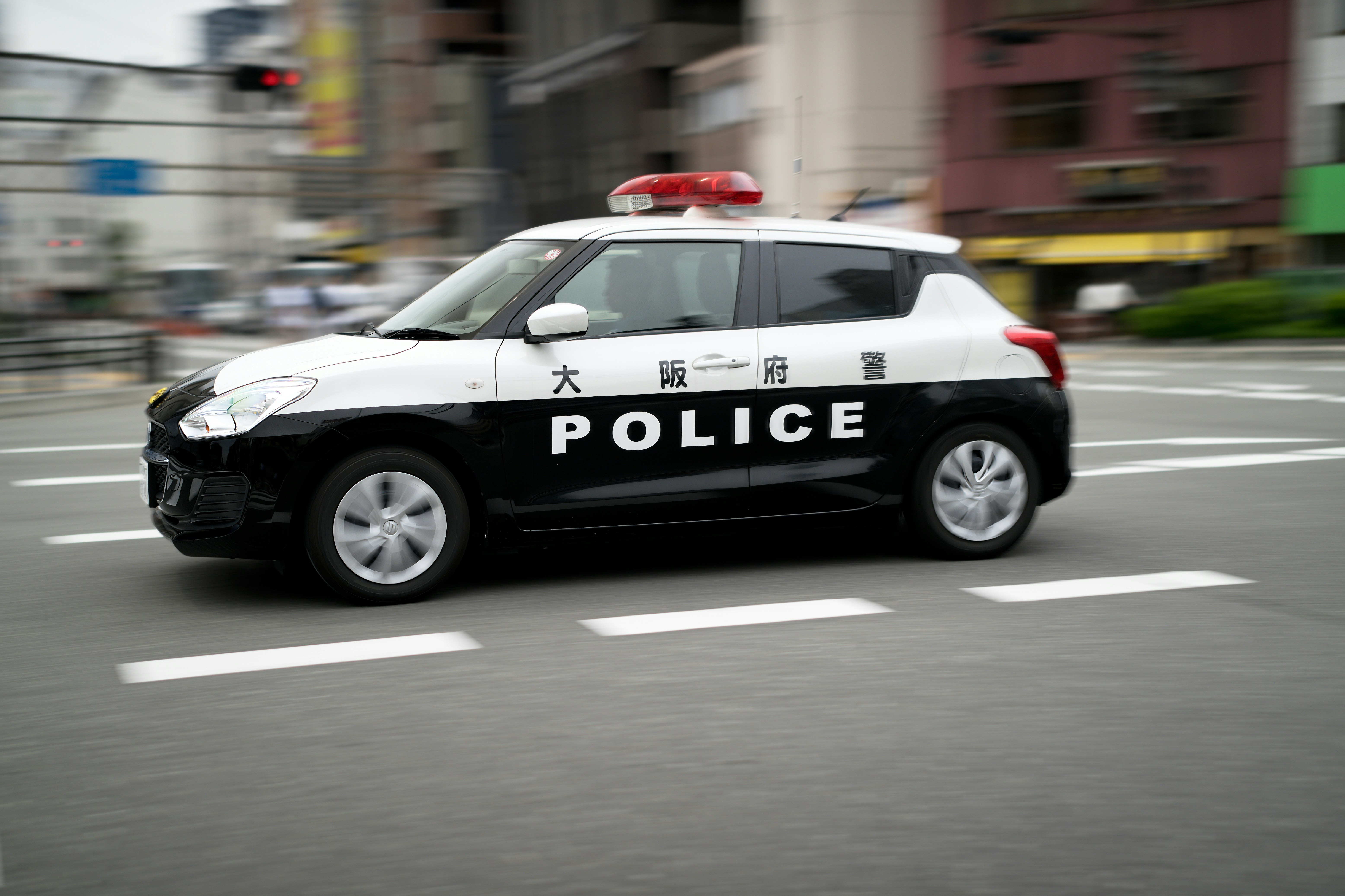 カメラを持ちながら街中を歩き、何気ない瞬間を撮影している若者のシーン