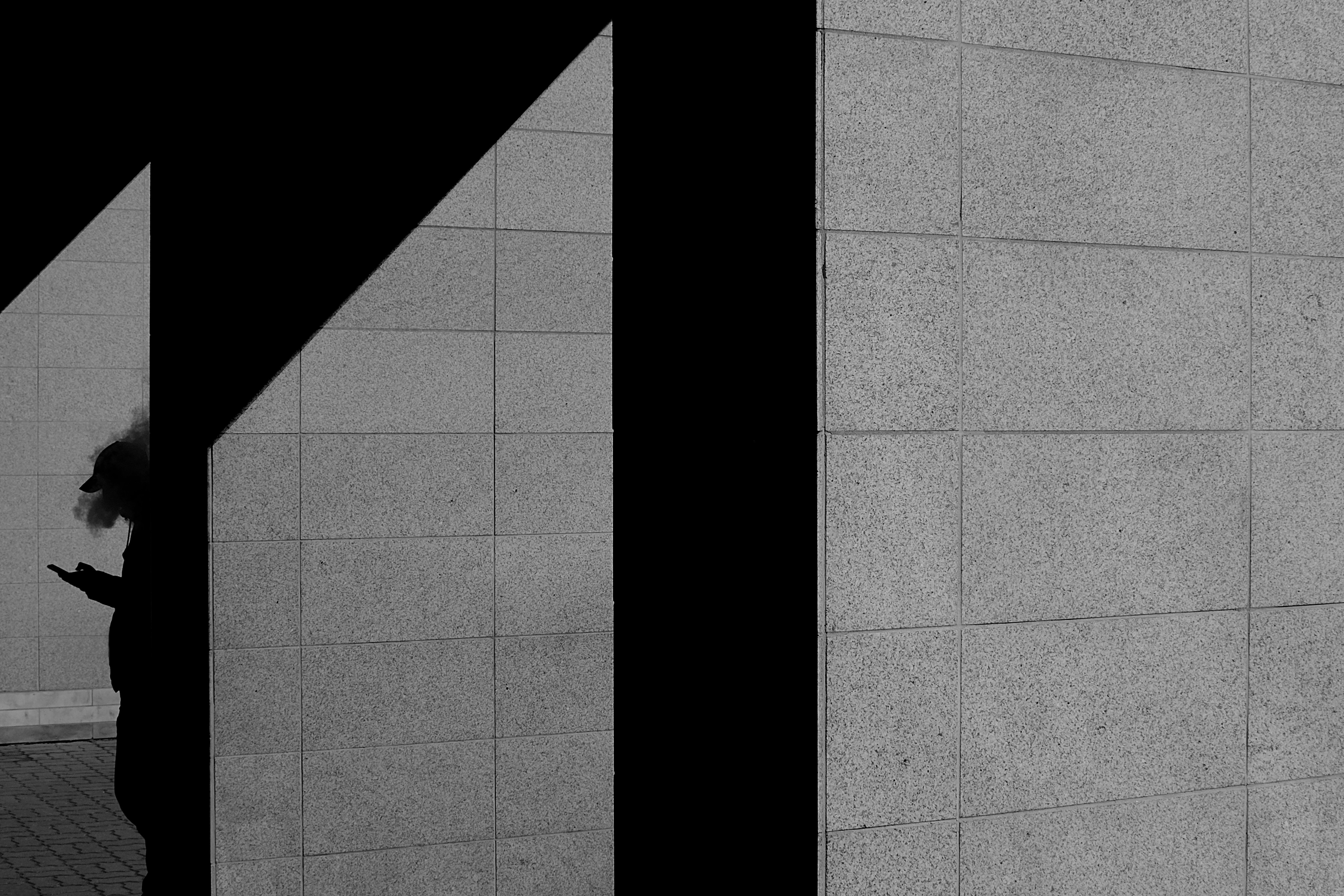 パソコン画面にクラウドソーシングサイトが表示され、周囲にデザインツールやノート、観葉植物が並ぶデスクの構図